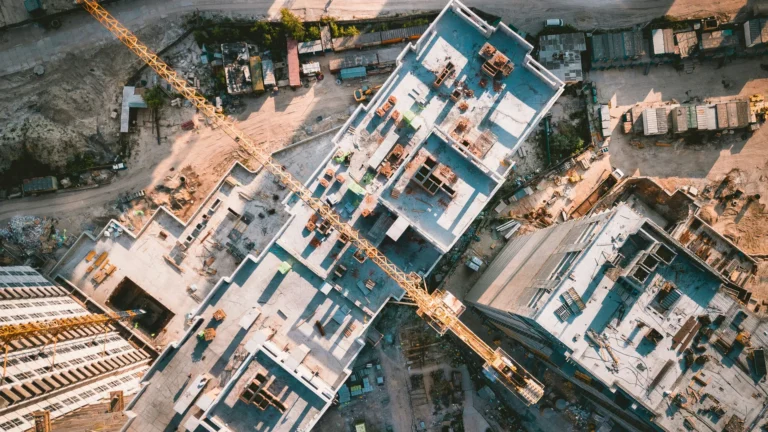 Aerial (straight down) view of a tower crane over a semi-finished set of buildings