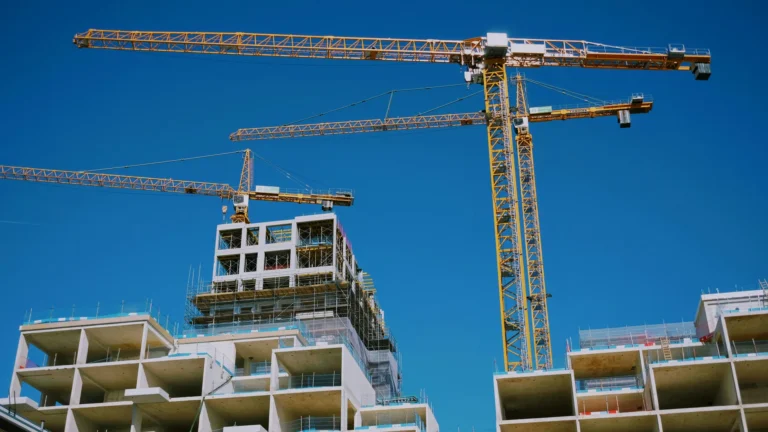 Tower cranes over a boxy but large work in progress building