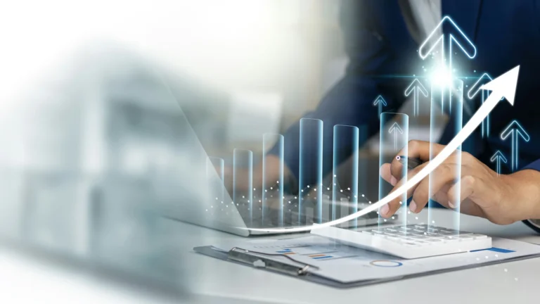 A transparent, glasslike, bar chart showing a general upward trend superimposed over person working on a laptop and a calculator